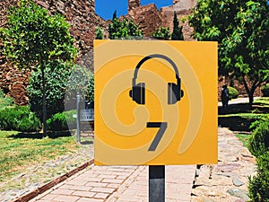 view of a music headphones icon with number 7 in a yellow sign board in the Alcazaba in the City of Malaga, Andalusia, Spain photo