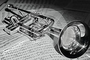 A view of the musical instrument which is the trumpet against the background of the sheet music