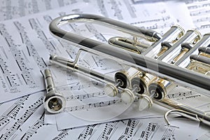 A view of the musical instrument which is the trumpet against the background of the sheet music