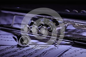 A view of the musical instrument which is the trumpet against the background of the sheet music