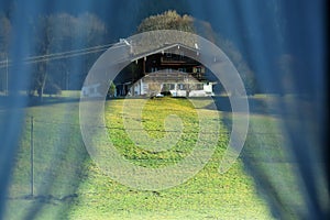 Piccolo casa sul montagna da vedere attraverso tende da mio 