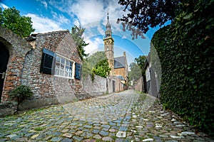 View through a narrow alley paved with cobble stones in the Dutch city