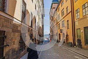 View of a narrow cobblestone tourist alley in Gamlastan, Stockholm, leading to the river waterfront.