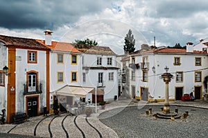 View of narrow main square consisting of limestone cozy yellow and white houses at Constancia in the Santarem District photo