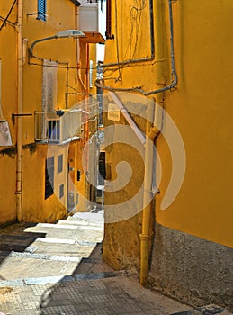 View of a narrow street with steps, old buildings and facades in the historical city of Agrigento in Sicily, Italy