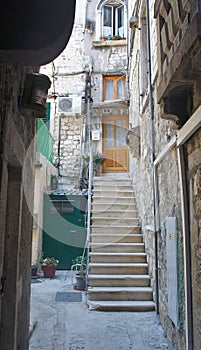 View of narrow street with stone houses and stairs in old town, beautiful architecture, sunny day, Split, Dalmatia, Croatia