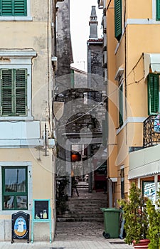 View of narrow street between two color old houses