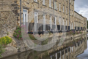 View from narrowboat traveling on a British canal in urban setting