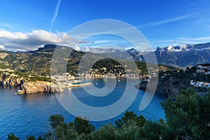 view of the natural bay and harbour of Port de Soller in northern Mallorca in warm evening light