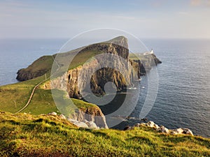 A view of the Neist Point Lighthouse on the green cliffs of the Isle of Skye