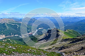 View of Nenana river valley from Mount Healy hike trail with blue sky with white clouds above. Denali National Park