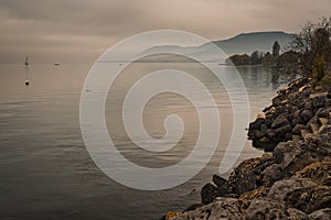 View of Neuchatel lake by beautiful misty sunset