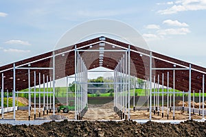 view of a new metal frame structure of an agricultural building under construction