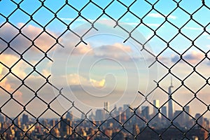 View on the New York city through the hole of steel mesh wire fence. C