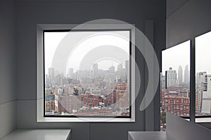 A view of New York City skyline from a window and a reflection on the mirror