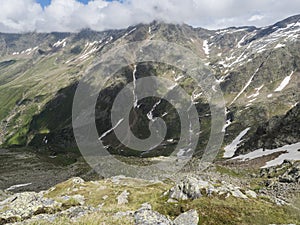 View from Niederl saddle on Nurnberger Hutte mountain hut and snow-capped peaks at Stubai hiking trail, Stubai Hohenweg photo