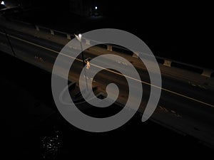 view of the night bridge over which cars pass. lamps dimly illuminate