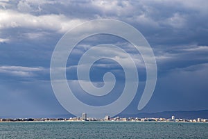 View of the night city with lights surrounded by the Black Sea and wrapped in clouds in the evening