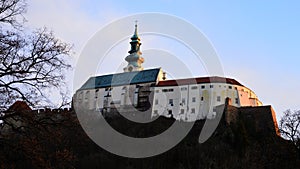 View of Nitra Castle with Saint Emeram Cathedral tower from northwestern side of park Sihot, in winter evening sunshine