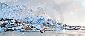 View of nordic fishing village on coastline with snow covered mountain on winter at Reine town, Lofoten islands, Norway