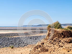 View of Northam Burrows on the Torridge and Taw estuary. Visible sand dunes and pebbles on sandy beach. Tide out. Dramatic