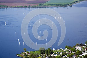 View of Nove Mlyny - Musov lake with boats, sailing boats and windsurfing in the rain in Palava