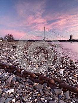 View of the Oberkasseler bridge from the banks of the river Rhine in DÃ¼sseldorf. Beautiful urban landscape at sunrise