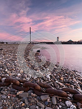 View of the Oberkasseler bridge from the banks of the river Rhine in DÃ¼sseldorf. Beautiful urban landscape at sunrise.