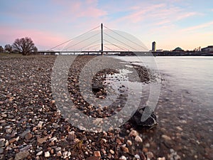 View of the Oberkasseler bridge from the banks of the river Rhine in DÃ¼sseldorf. Beautiful urban landscape at sunrise