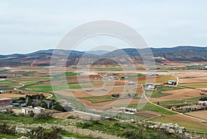 A view from observation deck to fields, farms and mountains near Consuegra town at spring cloudy day, Castilla La Mancha