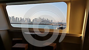 View of the ocean and the city with skyscrapers on the horizon from the cabin of a cruise liner. View of the city from the deck of