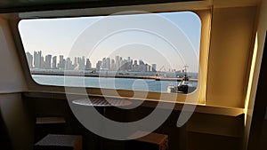 View of the ocean and the city with skyscrapers on the horizon from the cabin of a cruise liner. View of the city from the deck of