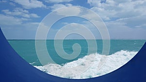 View of the ocean and clouds in the sky from the porthole of the ship.Blue sky with clouds in sunny weather over the ocean. Ocean