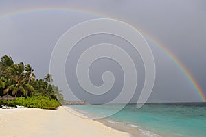 View of the ocean and the rainbow after the rain on a resort island in the Maldives