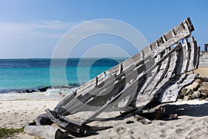 View on the ocean with turquoise water and a wooden ship wrack on the beach