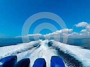 View of the ocean waves and the blue sky from back of a fast boat in Bali, Indonesia. Bali fast boat ride in Summer