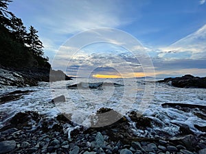 View of ocean waves crashing onto the shore and the clear blue sky of Nanaimo, Canada