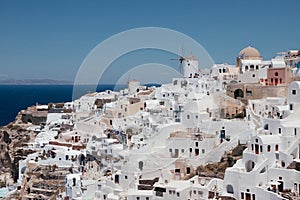 View of Oia town with mills in Santorini island in Greece. Summer vacation and holiday concept, luxury travel.