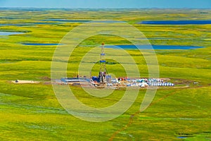 View of the oil rig in the tundra from a helicopter.