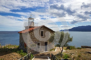 Abandoned stone lighthouse under a dramatic sky, Greece.