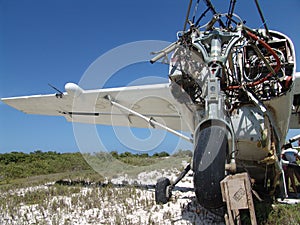 View of an old broken aircraft useless after crash at the beach under the blue sky