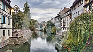 View of the old buildings on the riverbanks reflecting on river Ill, Strasbourg