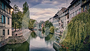 View of the old buildings on the riverbanks reflecting on river Ill, Strasbourg