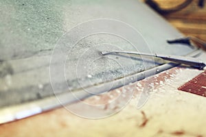 View of old car in garage with dusty hood dirty wind screen and broken windshield wiper. Concept of sale pre-owne cars