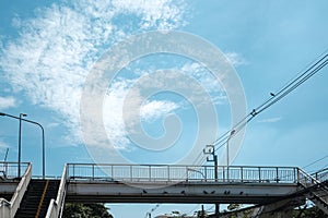 View of old cement stairs overpass to cross the street with metal handrails with blue sky in bangkok city
