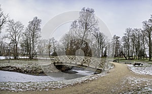 View of old decorative wooden bridge with locks in public park in winter. Love bridge