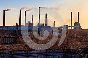 View of old factory with pipes with smoke. Air pollution, environmental damage