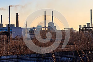 View of old factory with pipes with smoke. Air pollution, environmental damage