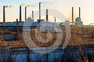 View of old factory with pipes with smoke. Air pollution, environmental damage