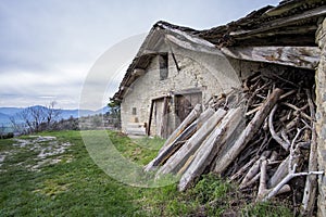 View of an old farm typical of the Pyrenees, borda, with a pile of wood stacked on the door photo